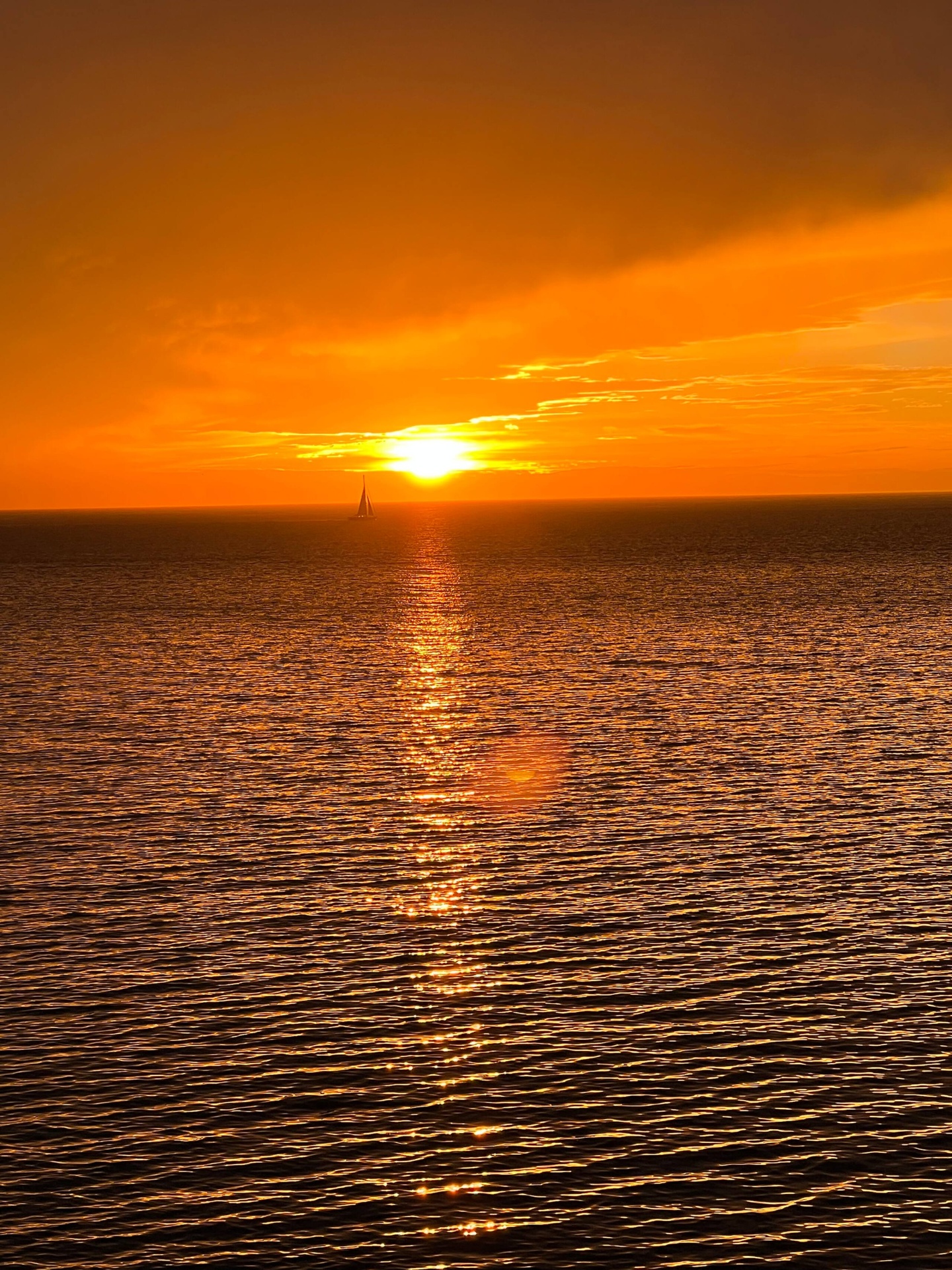Atardecer sobre el mar con velero