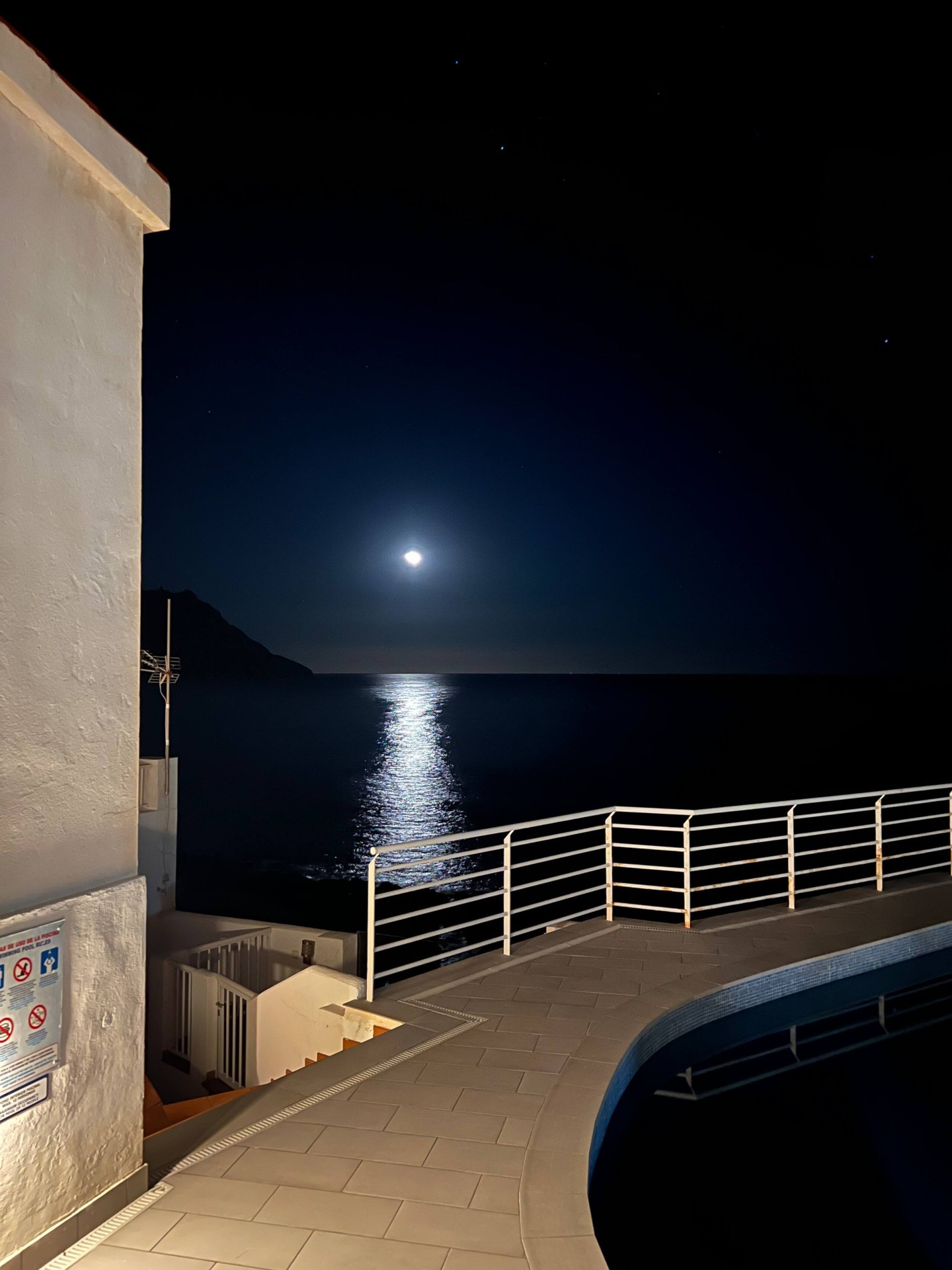 Vista nocturna con luna y piscina